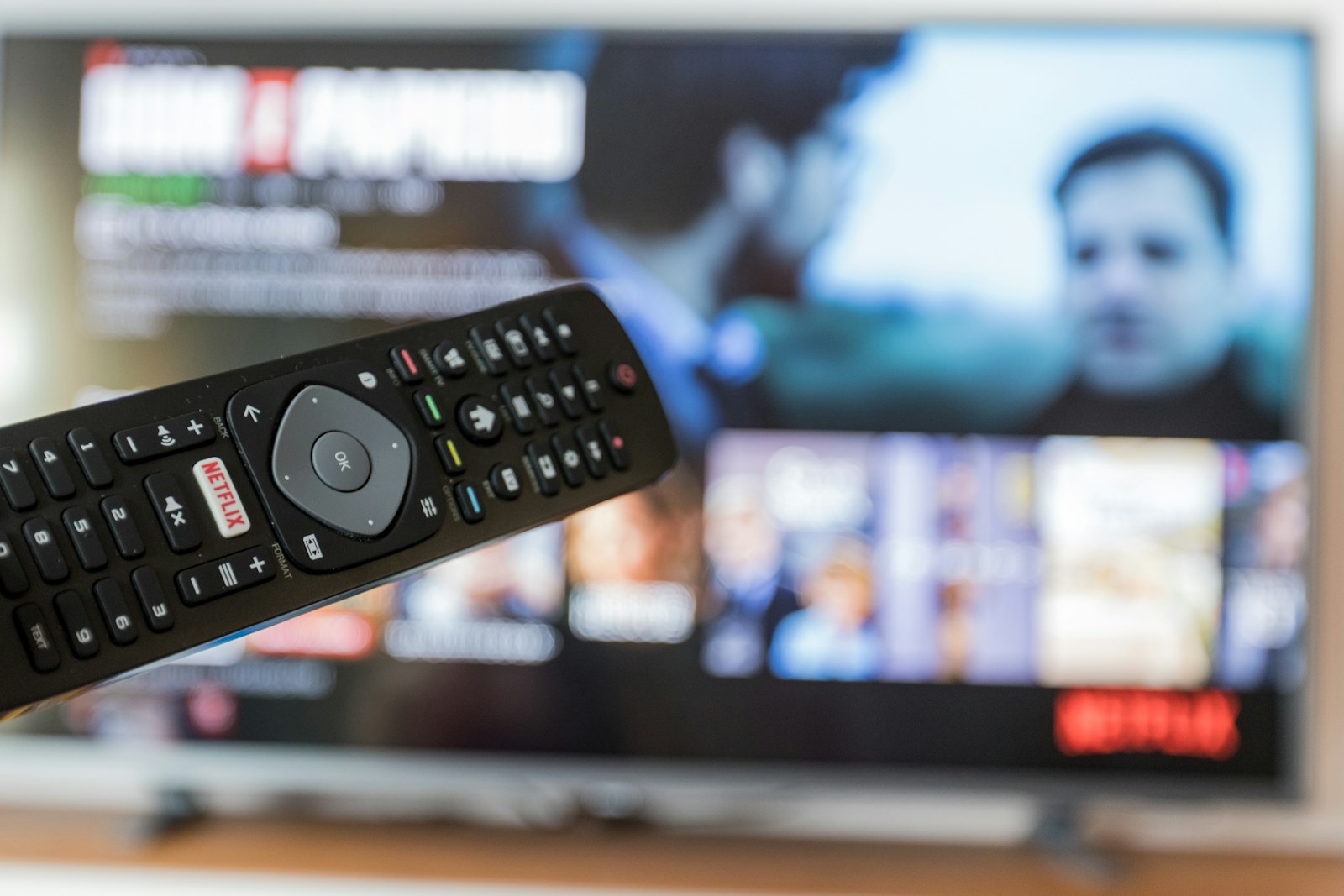 Télécommande de décodeur TV pointée vers un écran